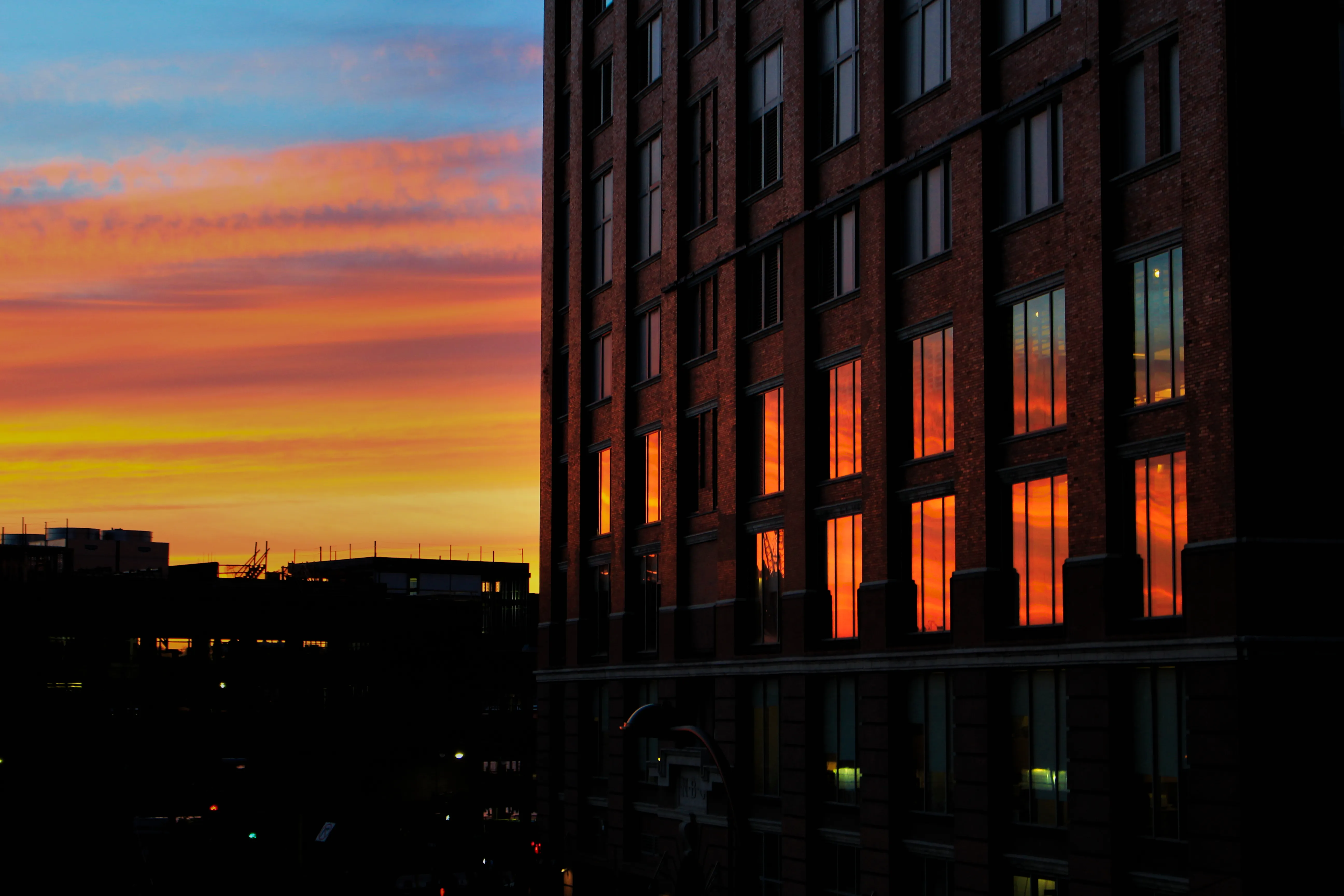 A sunset with reflections of the colors in a building's windows